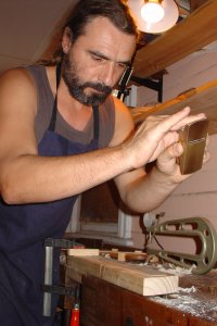Violin Maker Ilja Grawert planing a rib in his workshop in Brisbane Australia